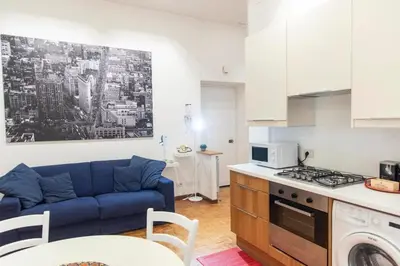 a living room with a blue couch in a kitchen at Nova Domus Colosseo in Rome