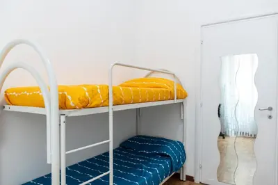 a bunk bed with orange and blue sheets on it at Nova Domus Colosseo in Rome