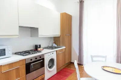 a kitchen with a stove and a washing machine at Nova Domus Colosseo in Rome