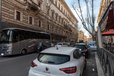 a white car parked on the side of a city street at Nova Domus Colosseo in Rome