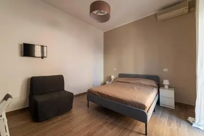 a bedroom with a bed and a chair at GuestHost - Monteverde Vecchio Apartment in Rome