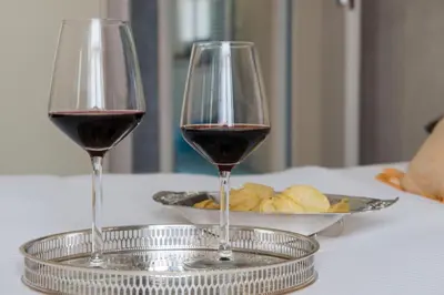 two glasses of red wine and a plate of bread at Datama House in Rome