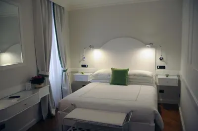 a bedroom with a bed with a green pillow on it at Suite Fontana di Trevi in Rome