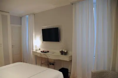 a bedroom with a bed and a desk with a television at Suite Fontana di Trevi in Rome