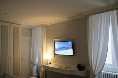 a room with a television on a wall with curtains at Suite Fontana di Trevi in Rome