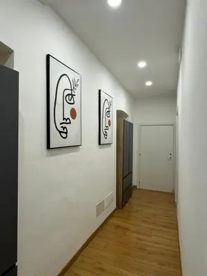 a hallway with three paintings on a white wall at Sweet House via dei gracchi in Rome