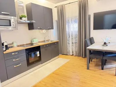 a kitchen with stainless steel appliances and a table at Sweet House via dei gracchi in Rome