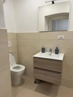 a bathroom with a toilet and a sink and a mirror at Sweet House via dei gracchi in Rome
