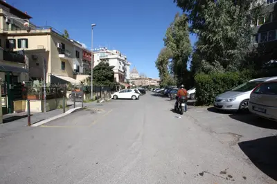 a man riding a bike down a street with parked cars at Sara Holiday House in Rome