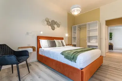 a bedroom with a large bed and a chair at Cornelia Elegance House in Rome