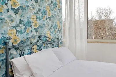 a bedroom with a bed with a floral wall at Homely Flat Porta Maggiore in Rome
