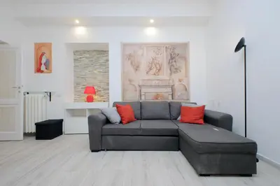 a living room with a gray couch with red pillows at Domus Monamì Apartment in Rome