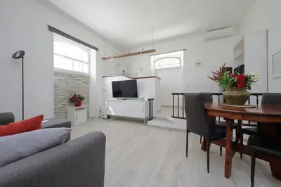 a living room with a table and a dining room at Domus Monamì Apartment in Rome