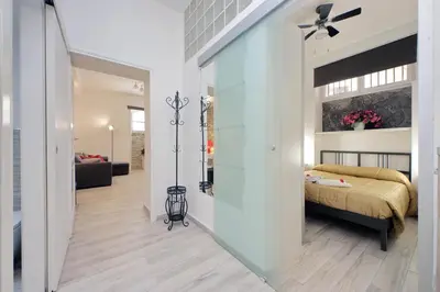a bedroom with a bed and a living room at Domus Monamì Apartment in Rome