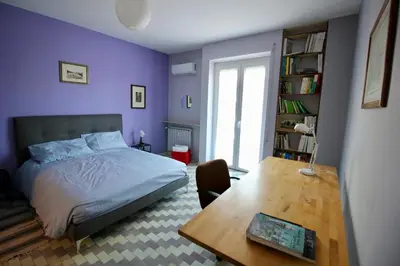 a bedroom with purple walls and a bed and a table at CASA UMBERTO in Rome