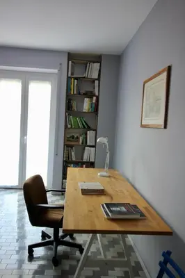 an office with a desk and a chair and a book shelf at CASA UMBERTO in Rome
