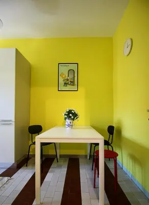 a dining room with a table and a yellow wall at CASA UMBERTO in Rome