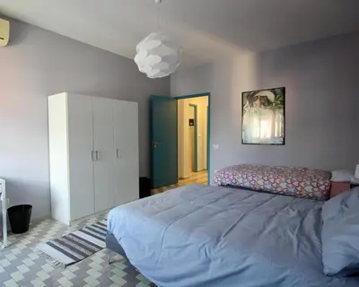 a bedroom with a large bed and a white cabinet at CASA UMBERTO in Rome
