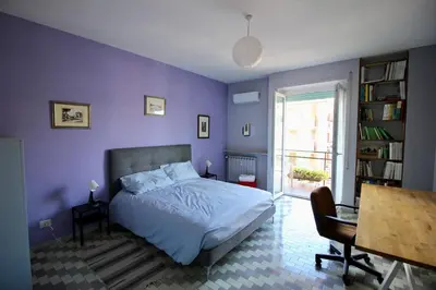 a bedroom with purple walls and a bed with a desk at CASA UMBERTO in Rome