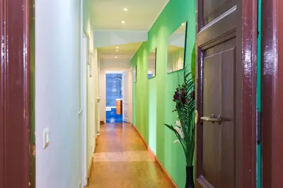 a hallway with green walls and a wooden door at Home Candia in Rome