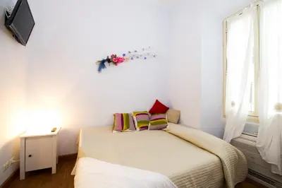 a small bedroom with two beds and a window at Home Candia in Rome