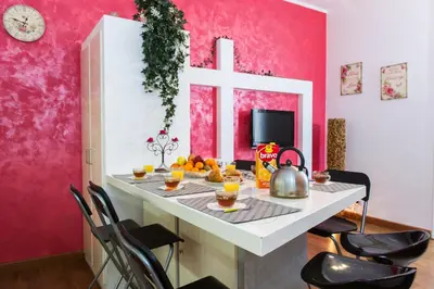a room with a table with oranges and a cross on the wall at Home Candia in Rome