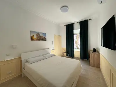a bedroom with a bed and a flat screen tv at Costantino Rooms in Rome
