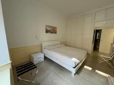 a bedroom with a bed and a chair in it at Costantino Rooms in Rome