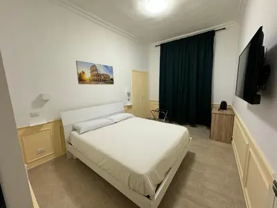 a bedroom with a bed and a flat screen tv at Costantino Rooms in Rome