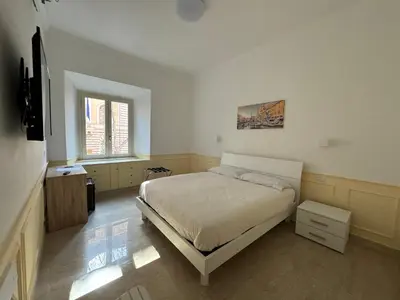 a bedroom with a bed and a television in it at Costantino Rooms in Rome