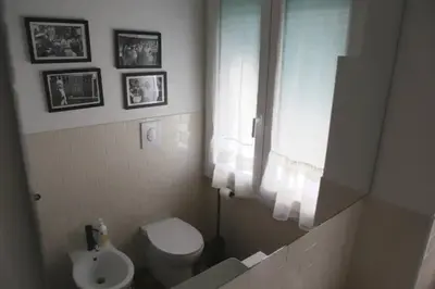 a bathroom with a white toilet and a sink at Porta Maggiore Modern Apartment in Rome