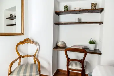 a room with a chair and a mirror at Pantheon Boutique Apartment in Rome