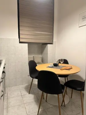 a dining room table with black chairs and a table at Pietra Apartment 2 , Colosseo in Rome