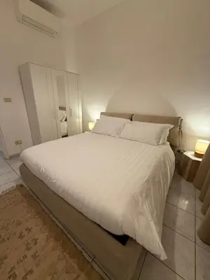 a bedroom with a large bed with white sheets and pillows at Pietra Apartment 2 , Colosseo in Rome