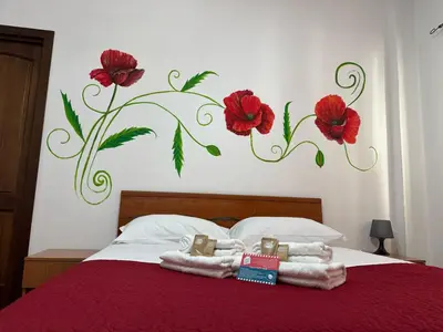 a bedroom with a bed with towels and flowers on the wall at Trastevere Marconi Apartment in Rome