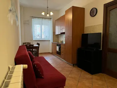 a living room with a red couch and a television at Trastevere Marconi Apartment in Rome