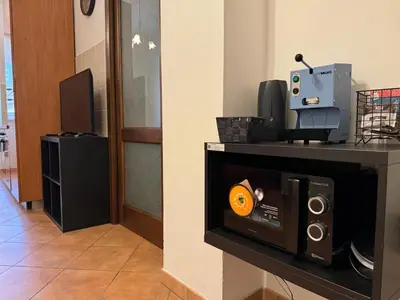 a room with a tv and a speaker on a wall at Trastevere Marconi Apartment in Rome