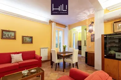 a living room with a red couch and a table at Casa Rio by Hili in Rome