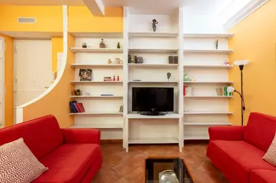 a living room with two red couches and a tv at Casa Rio by Hili in Rome
