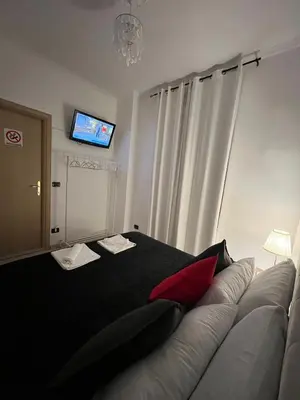 a bedroom with a couch with a red pillow on it at centro stazione tuscolana in Rome