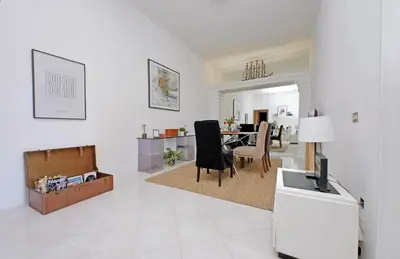 a white living room with a table and chairs at Giant Cola di Rienzo Apartment in Rome