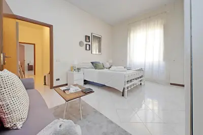 a white bedroom with a bed and a table at Giant Cola di Rienzo Apartment in Rome