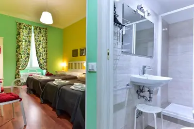 a bathroom with a sink and a room with two beds at Best Rooms Termini in Rome
