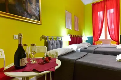 a room with two beds and a table with a bottle of wine at Best Rooms Termini in Rome