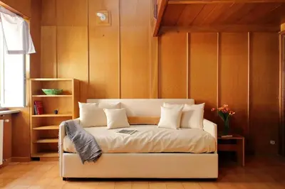 a bed in a room with wooden walls at Appartamento 