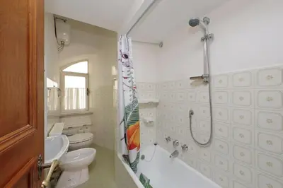 a bathroom with a shower and a toilet and a sink at Appartamento 