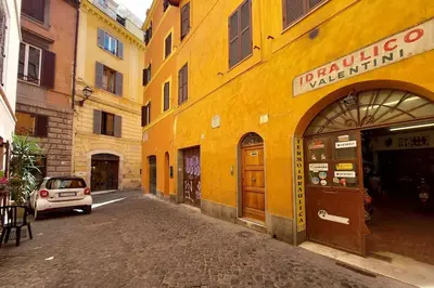 a yellow building with a car parked on a street at Appartamento 