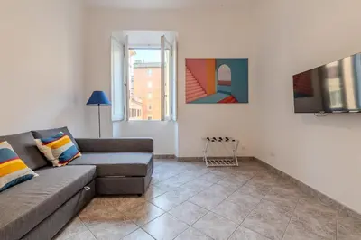 a living room with a couch and two windows at Tomo Apartment St. Peter's in Rome