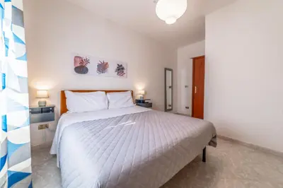 a bedroom with a large bed with white sheets at Luisa Flat - Metro Basilica San Paolo - Wi-Fi in Rome