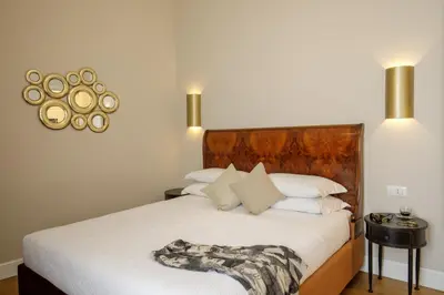 a bedroom with a white bed with a wooden headboard at Daplace - Santa Susanna Suites in Rome